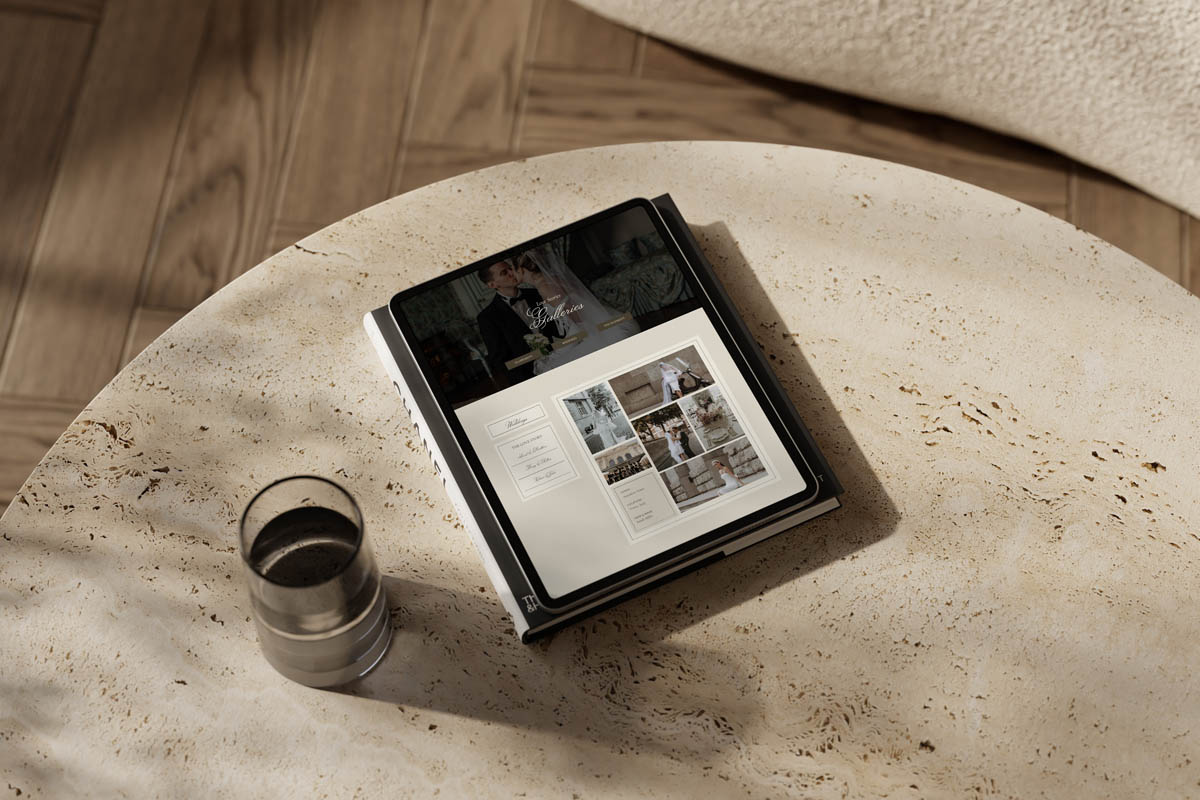 Tablet displaying a wedding photography website on a round stone table with natural light, illustrating how users explore visual portfolios before contacting a service provider.