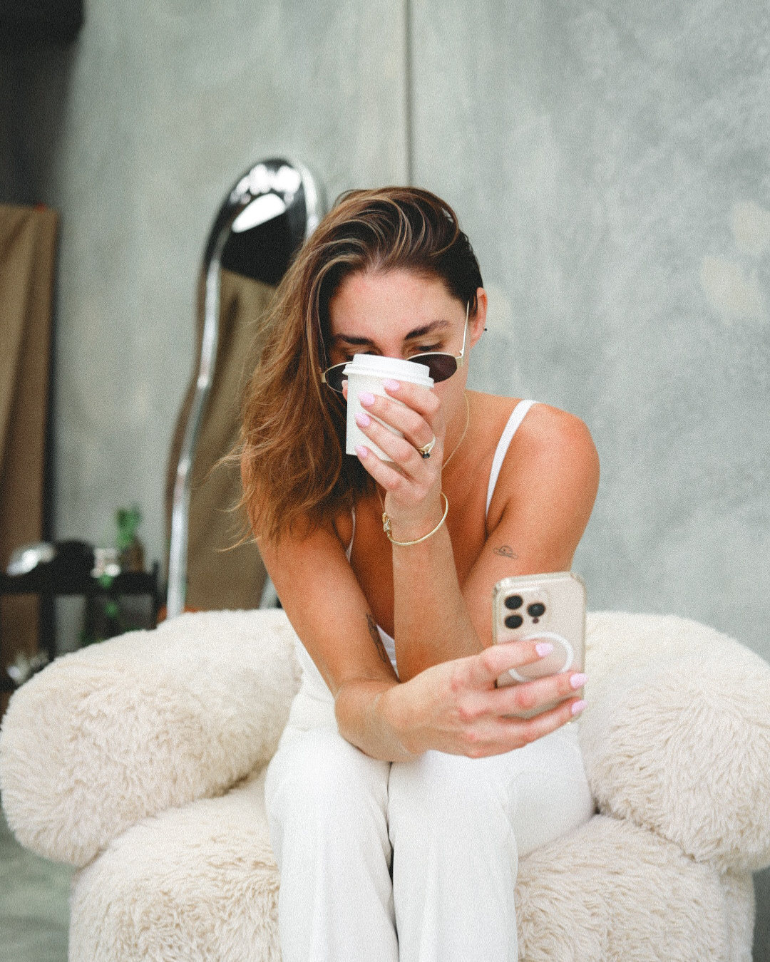 woman checking google business profile on smartphone during studio coffee break